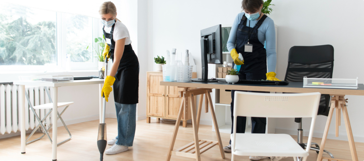 People cleaning an office with cleaning supplies
